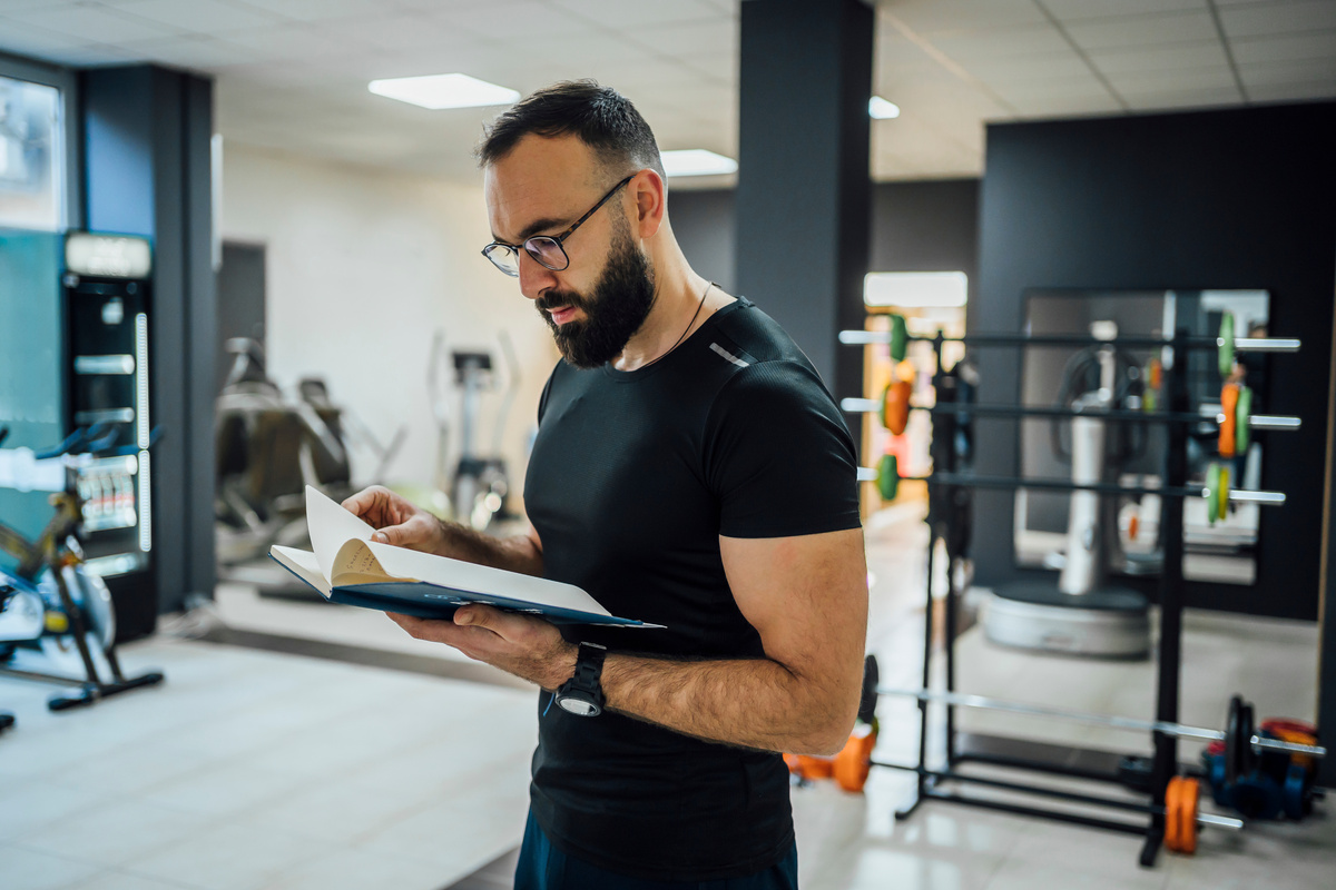 Male fitness trainer reading schedule